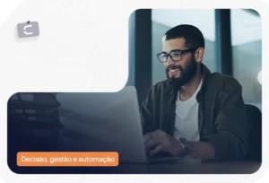 Homem de óculos utilizando notebook em escritório, com o logotipo da marca 'C' no canto superior e etiqueta laranja destacando 'Decisão, gestão e automação', ilustrando um motor de crédito.