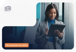 Mulher sorridente usa tablet em escritório com etiqueta 'Recuperação de crédito'.